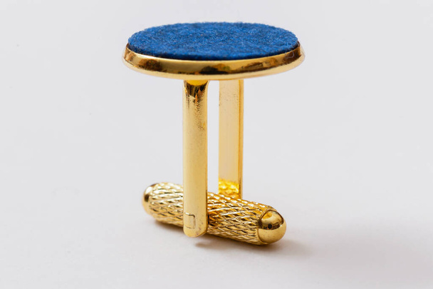 zlatý kovový manžetový knoflík s modrou plstí na bílém pozadí - Fotografie, Obrázek