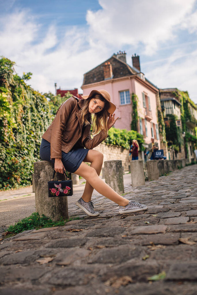 A beautiful young woman in a brown jacket walks in the early morning on the famous Montmartre hill in Paris, France - 写真・画像