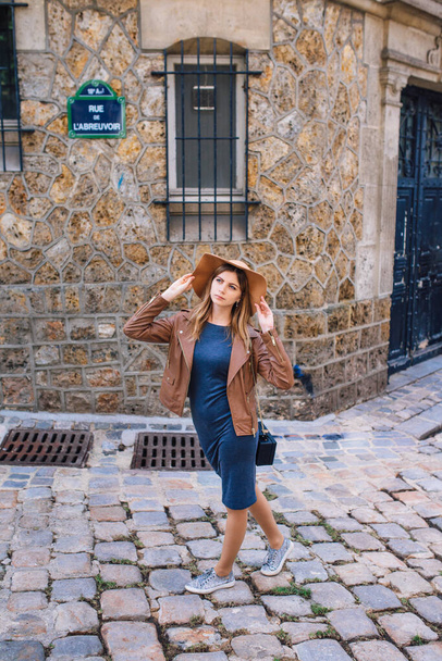 Una hermosa joven con una chaqueta marrón camina por la mañana temprano en la famosa colina de Montmartre en París, Francia
 - Foto, imagen