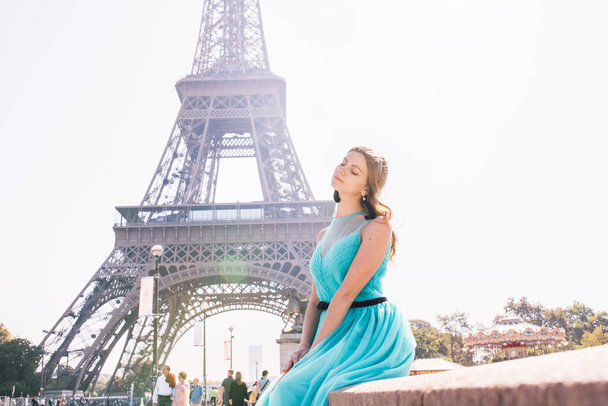 Beautiful young woman near the Eiffel tower in Paris, France - Foto, afbeelding