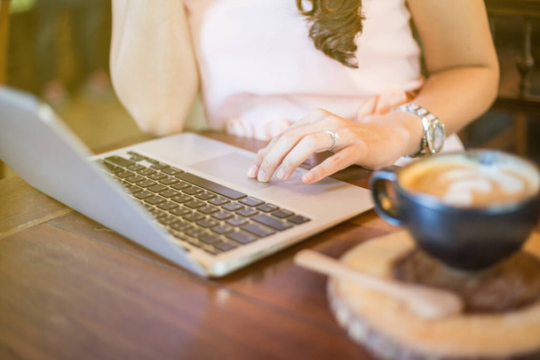 Азиатские деловые женщины, сидящие в арт-кафе, используют ноутбук для онлайн-работы
 - Фото, изображение