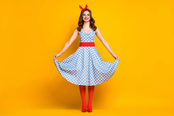 Full size photo of cheerful lovely girl enjoy spring free time holiday weekend touch her polka-dot outfit shine stockings isolated over vivid color background - Photo, Image