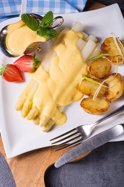 Asparagus with fried potatoes and hollandaise sauce - 写真・画像