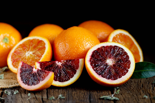 Viipaloitu Sisilian Veri appelsiinit hedelmiä vanha tumma puinen tausta. Yläkuva. - Valokuva, kuva