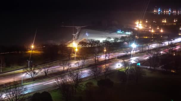 Zoom out timelapse sentiero leggero del traffico sul lago Shore Drive di notte con fari e fanali posteriori accanto al lago Michigan come nuvole navigare nel cielo notturno buio sopra
. - Filmati, video