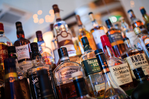 Various bottles of alcoholic beverages on the shelf in the bar - Fotoğraf, Görsel
