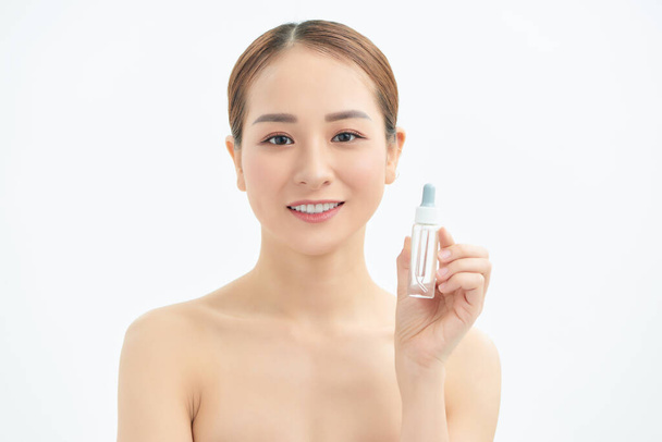 Beautiful young Asian woman showing skin care product isolated on white background. - Photo, Image