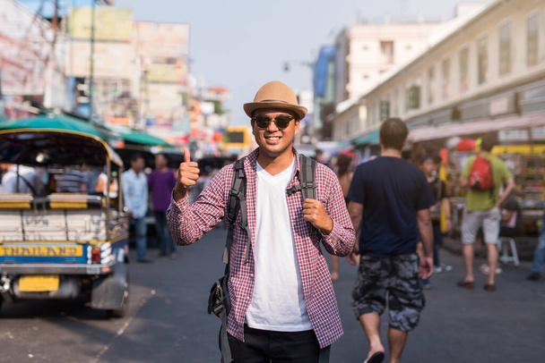 Genç Asyalı gezgin adam Bangkok 'ta Khaosan Yolu' nda yürüyor. - Fotoğraf, Görsel