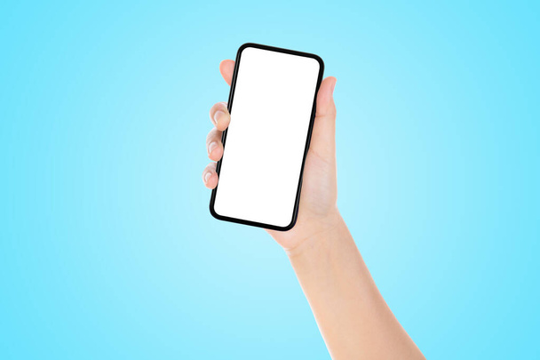 Concept de communication d'affaires : main tenant vieux smartphone noir avec fond bleu
. - Photo, image