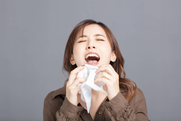 Chora młoda kobieta dmucha w nos - Zdjęcie, obraz