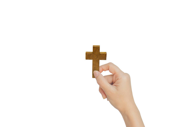 Main féminine tenant une croix en bois isolée sur fond blanc
. - Photo, image