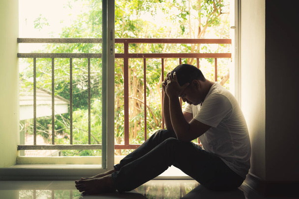 Печальный человек смотрит в окно в драматической концепции
 - Фото, изображение