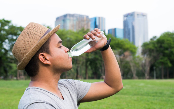 joven guapo asiático hombre beber agua
 - Foto, imagen