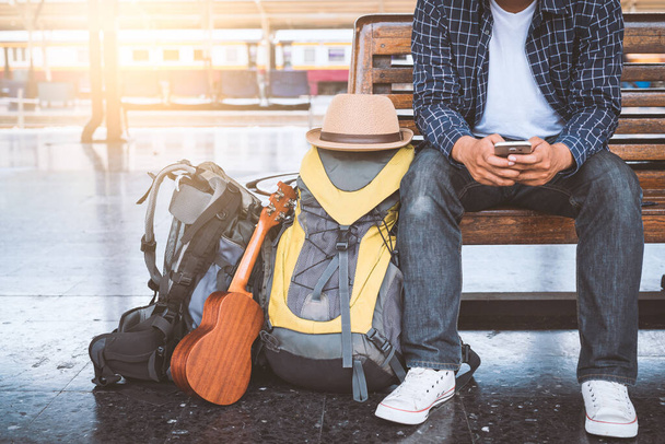 Homem viajante usando smartphone para planejar a viagem na estação ferroviária de Bangkok
 - Foto, Imagem