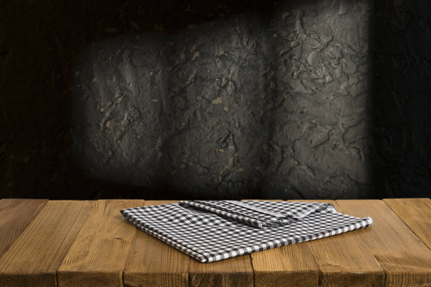 Old wood table with blurred concrete block wall in dark room background. - Фото, зображення