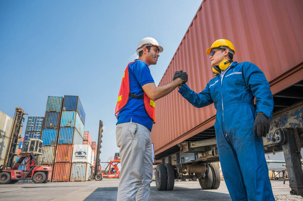 Foreman and dock worker staff shaking hand for sucess working at Container cargo harbor. Business Logistics import export shipping concept. - Photo, image