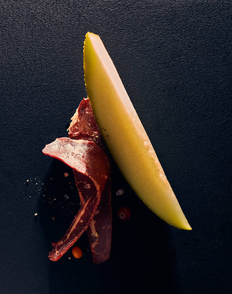melon and ham is a masterpiece on a black background - Foto, immagini