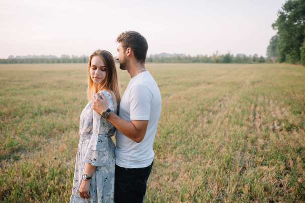 A girl and a guy are walking in the park. Portrait of a couple, a love story.Happy smiling, loveling couple together outstretched at beautiful nature. Lovestoty - Foto, Bild