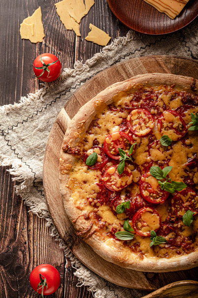 Rustic homemade pizza with sharp cheddar chesse and spicy salami - Foto, afbeelding