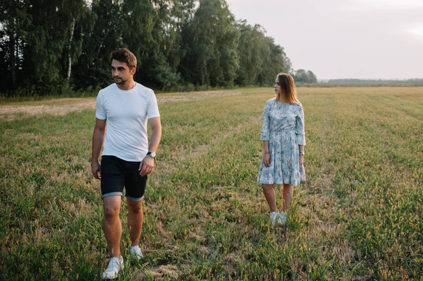 A girl and a guy are walking in the park. Portrait of a couple, a love story.Happy smiling, loveling couple together outstretched at beautiful nature. Lovestoty - Фото, зображення