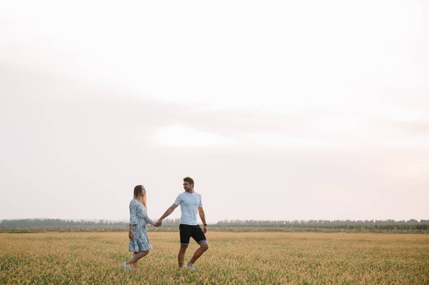 A girl and a guy are walking in the park. Portrait of a couple, a love story.Happy smiling, loveling couple together outstretched at beautiful nature. Lovestoty - Fotoğraf, Görsel