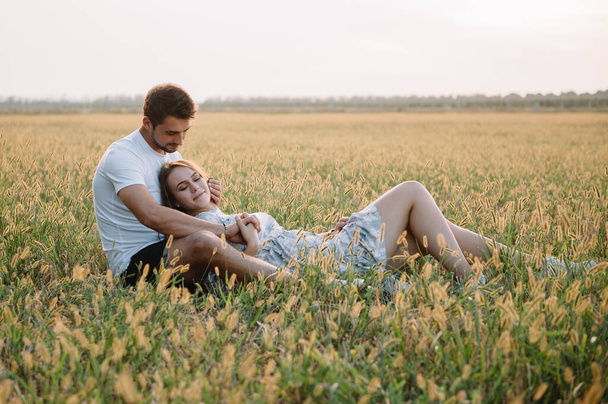 A girl and a guy are walking in the park. Portrait of a couple, a love story.Happy smiling, loveling couple together outstretched at beautiful nature. Lovestoty - Fotó, kép