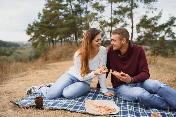 Portret van happy couple in liefde dating buiten in het Park op een zonnige dag. Romantisch paar liggend op de deken op het gras tijdens een picknick in de natuur achtergrond. Valentine dag. Gelukkige relatie - Foto, afbeelding