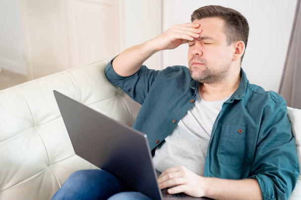 businessman with head hurts working lying on couch - Photo, image