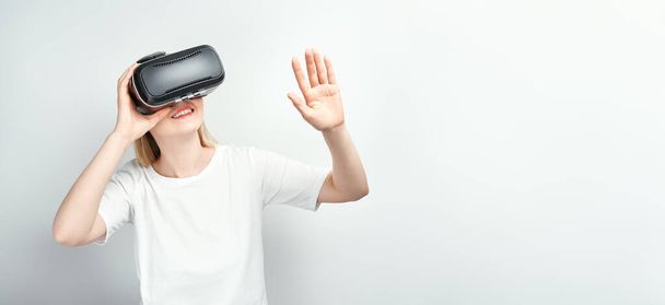 χαρούμενη χαμογελαστή νεαρή όμορφη κοπέλα l πάρει την εμπειρία χρησιμοποιώντας VR-ακουστικά γυαλιά της εικονικής πραγματικότητας στο σπίτι πολύ χειρονομίες χέρια - Φωτογραφία, εικόνα