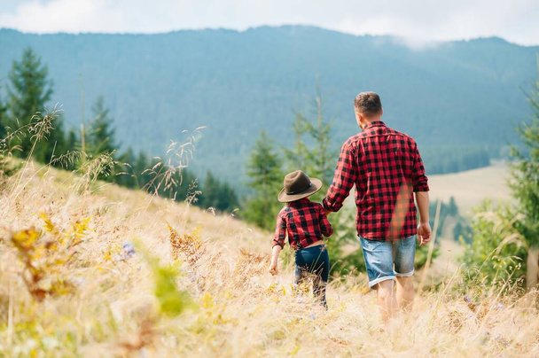 Padre feliz y niño pequeño están caminando en las montañas. Día del Padre. vacaciones en el parque nacional
 - Foto, imagen