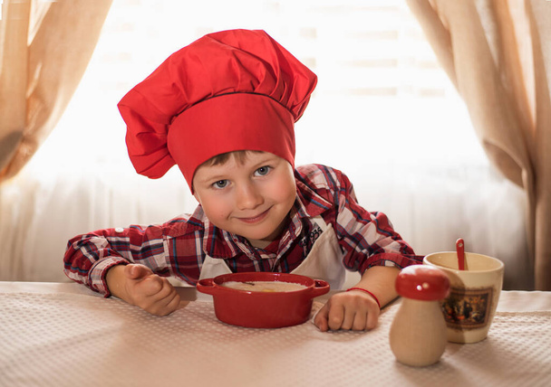 Chlapec v kuchařském klobouku připravuje pečení, velikonoční dort - Fotografie, Obrázek