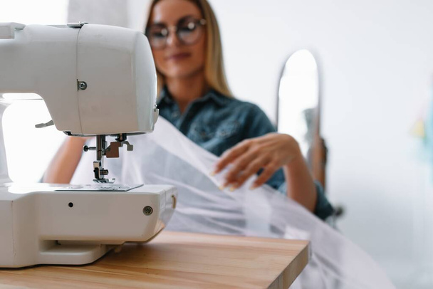 sewing machine, pink fabric and women's hands - Foto, imagen