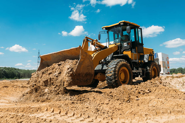 duży żółty buldożer ciągnika na placu budowy w piasku w pracy - Zdjęcie, obraz