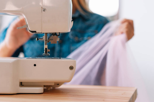 sewing machine, pink fabric and women's hands - Фото, зображення