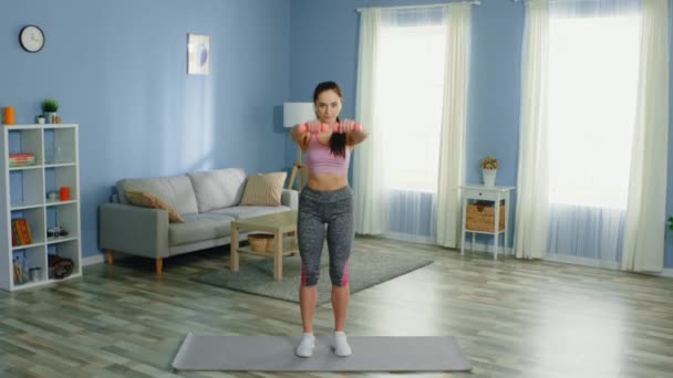 Mujer joven está haciendo ejercicio de brazo en casa
 - Imágenes, Vídeo