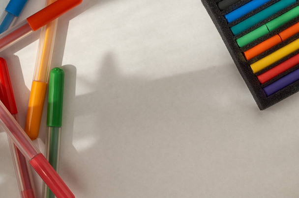 tekening met pasteltekeningen en viltstiften. Multi-gekleurde pastelstukjes in een verpakking en viltstiften - Foto, afbeelding