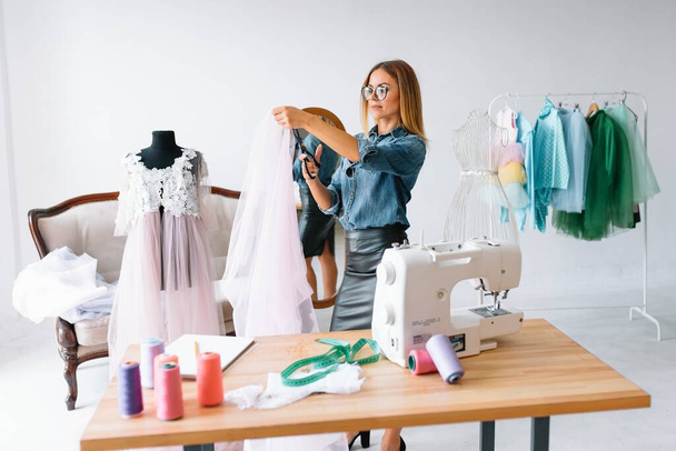Authentic image of a fashion designer working in her studio - Photo, image