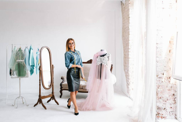 happy young fashion deisgner in her studio. concept of tailoring - Foto, immagini