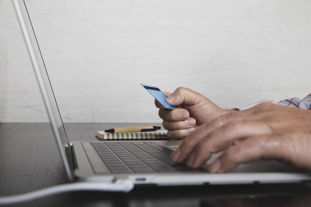 Mãos de homem segurando cartão de crédito e usando laptop. Compras online. Compras online
 - Foto, Imagem