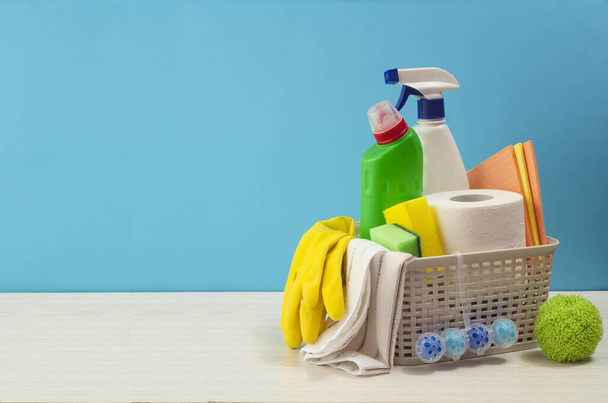 Cleaning set for different surfaces in kitchen, bathroom and other rooms. Empty place for text or logo on blue background. Cleaning service concept. Early spring regular clean up. Front view. - Foto, Imagen