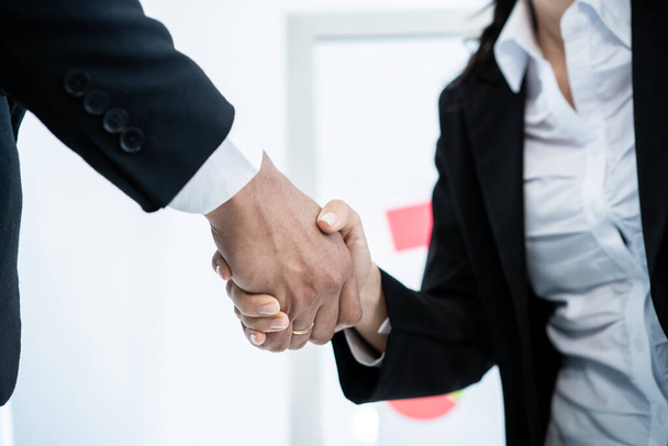 Asian and caucasian ethnicity businesspeople doing a handshake together after done and completed business negotiation. Trust in business partnership and colleague. Successful in business concept. - Foto, imagen
