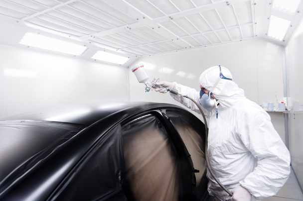Automotive mechanical engineer painting the body of a black car - Foto, Imagem