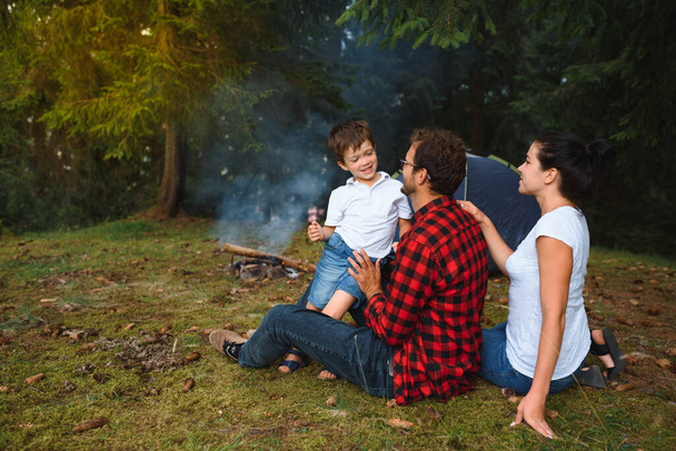family vacation in the mountains camp. Family in love happy relaxing nature background. Love concept. Camping vacation. Camping in mountains. Family travel. Summer vacation. Family near camping tent. - 写真・画像