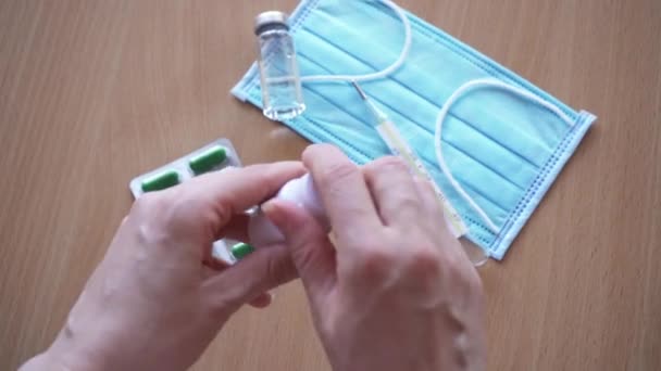 Tabletta a kézben közelkép. A közeli női kezek fehér tablettát öntenek az üvegből a tenyérbe. 4k felvétel - Felvétel, videó