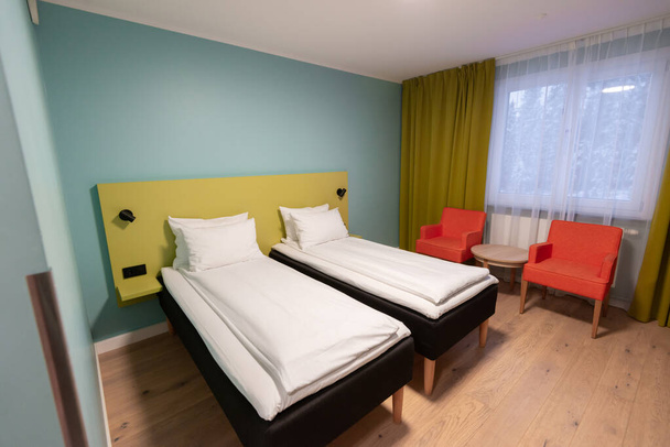 Cama doble blanca interior con almohadas en el dormitorio moderno del hotel
 - Foto, imagen