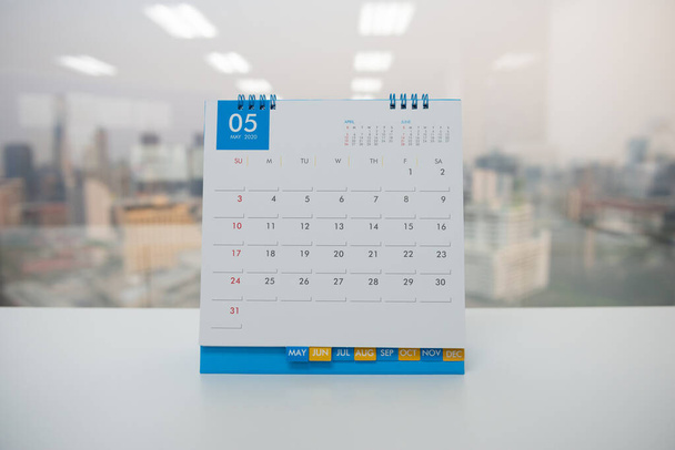 Calendario di maggio sul tavolo bianco con sfondo vista città
 - Foto, immagini