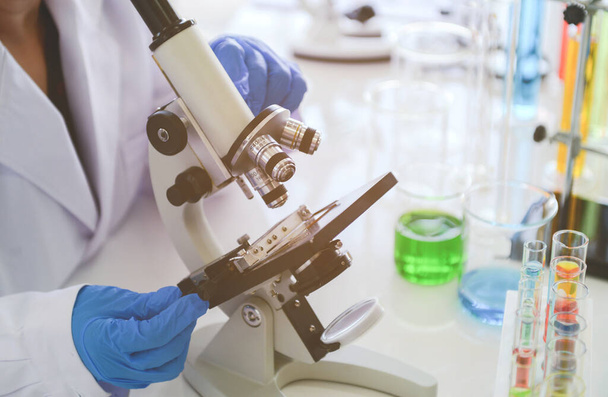 Tıbbi araştırmacılar mikroskobu kimyasal kucakta kullanıyor. - Fotoğraf, Görsel