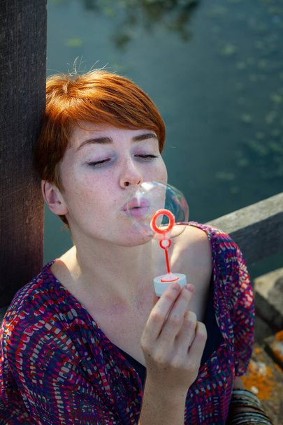PORTRAIT OF WOMAN SITTING ON A GANGWAY WITH BUBBLE - Photo, Image
