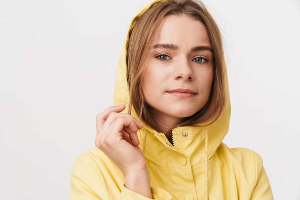Photo of serious caucasian woman in raincoat posing and looking aside isolated over white background - Foto, afbeelding