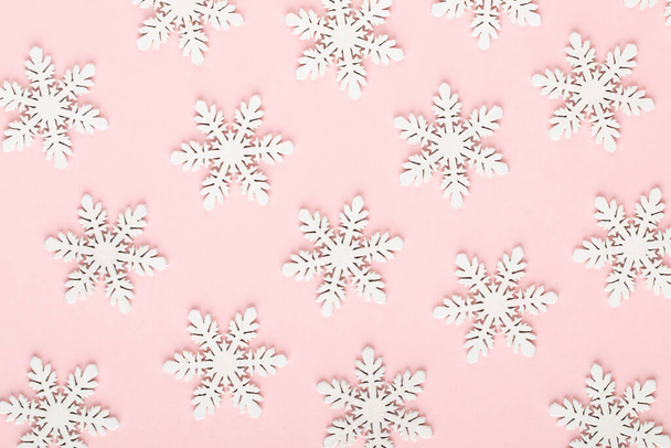 Christmas background. White snow decorations on a pink background. - Foto, Imagen